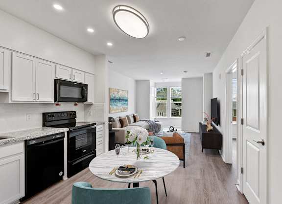A modern kitchen with a dining table set for two.
