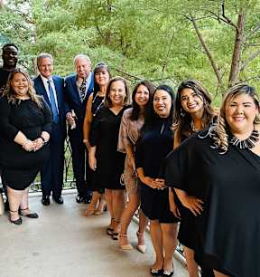 a group of people in black dresses posing for a picture