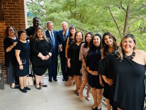 a group of people in black dresses posing for a picture