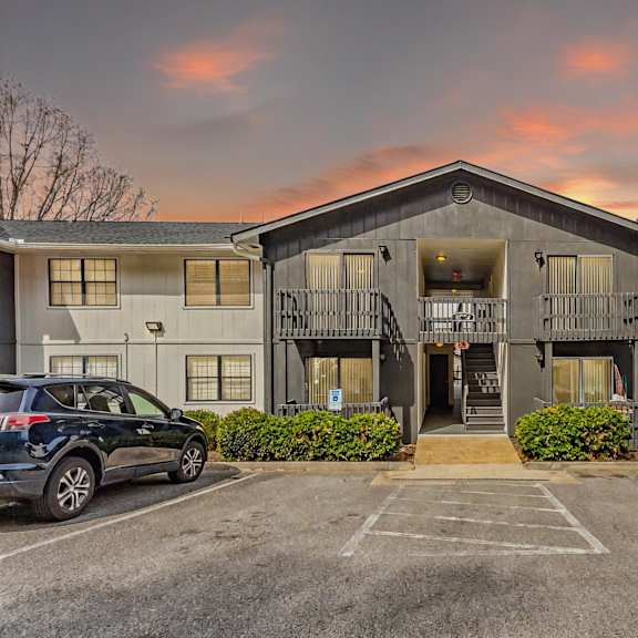 Apartment building with a parking lot in front.