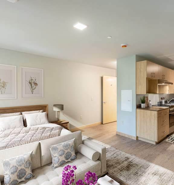 A bedroom with a large bed and a couch with pillows.