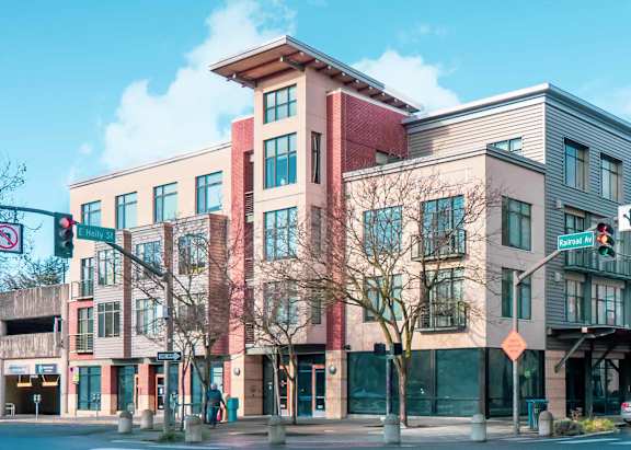 A street view of a multi-story building with a red and beige facade.
