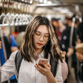 a woman on a subway train looking at her phone