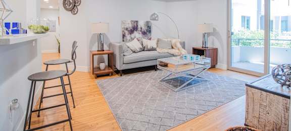 A living room with a grey couch and a grey rug at Woodley Sara Apartment, Van Nuys, 91406