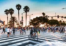 a large crowd of people crossing a cross walk