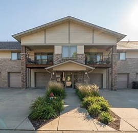 the front of a house with two garages and a sidewalk