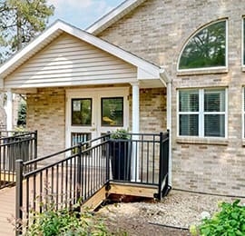 the front of a house with a porch and a fence