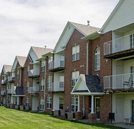 a row of houses with balconies and a lawn