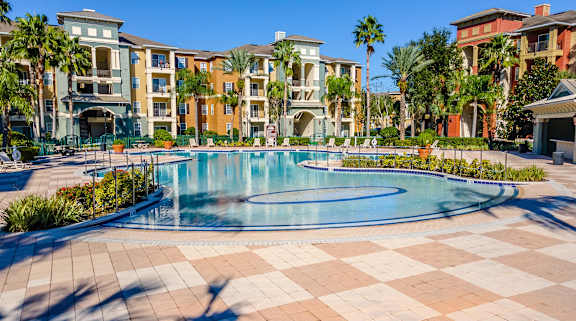 a large swimming pool with apartments in the background
