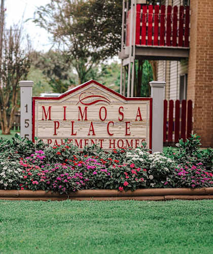 A sign for Milosa Place Apartment Homes is in front of a building.