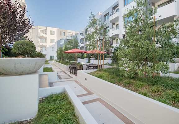 A white concrete pillar sits in the middle of a walkway at Woodley Sara Apartment, Van Nuys, 91406