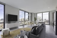 a living room with a gray couch and a yellow rug