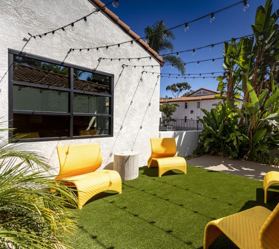 a yard with yellow chairs and a green lawn at La Jolla Blue, San Diego, California, 92122