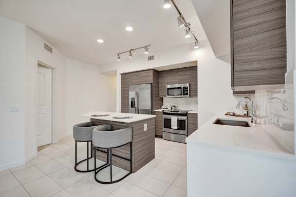 A modern kitchen with a bar area and a microwave above the stove.