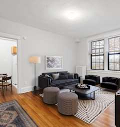 a living room with two couches and a rug and a dining room table