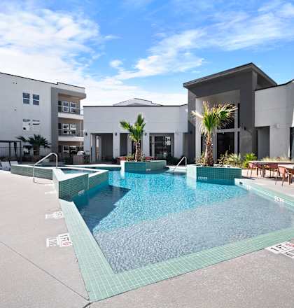 A swimming pool in a courtyard surrounded by buildings.