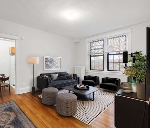 a living room with two couches and a rug and a dining room table