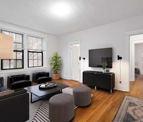 a living room with black furniture and a tv