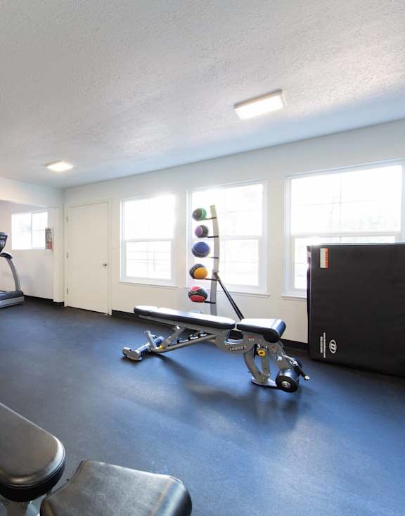 A long hallway with a table and chairs on the right side.