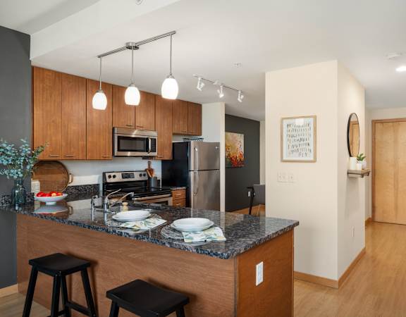 a kitchen with a granite counter top and a stainless steel refrigerator