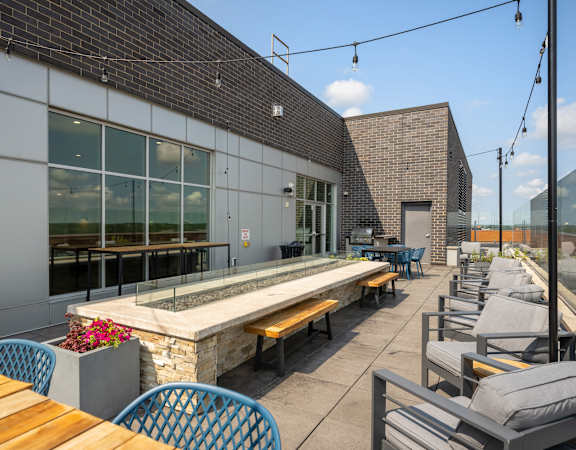 a patio with tables and chairs and a building with large windows