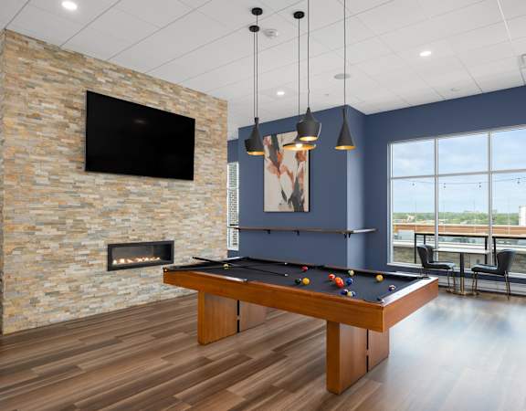 a games room with a pool table and a fireplace