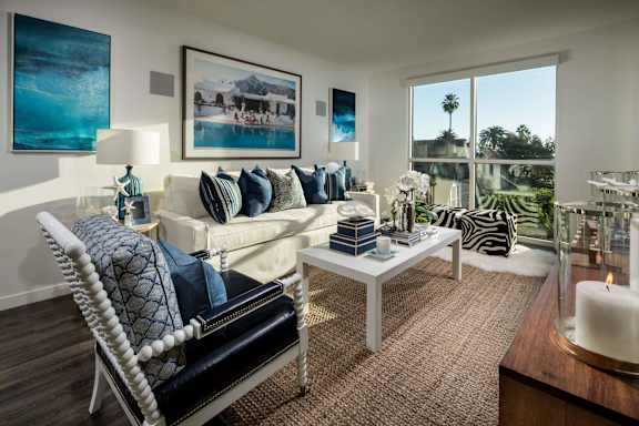 A living room with a white sofa and a large window.