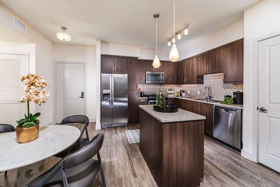 A kitchen with a table and chairs.