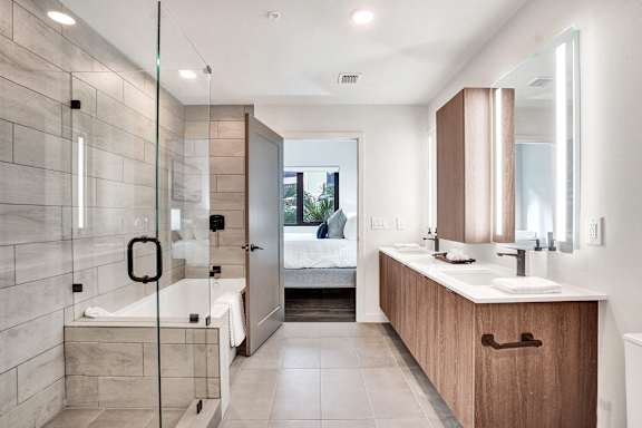 A modern bathroom with a walk-in shower and double sinks.