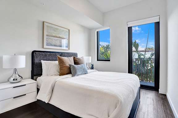 A bedroom with a large bed and a painting on the wall.