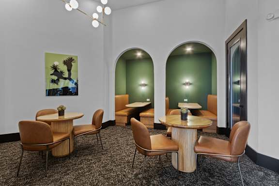A room with a table and chairs and a painting on the wall.