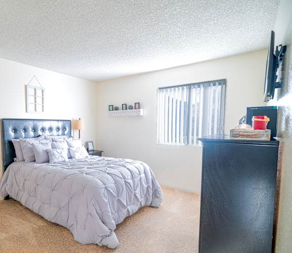 A bedroom with a bed, nightstand, and window.