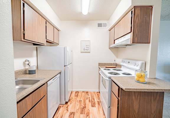 A small kitchen with wood cabinets and white appliances.