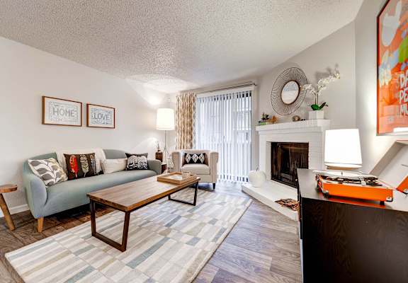 a living room with a couch and a coffee table and a fireplace