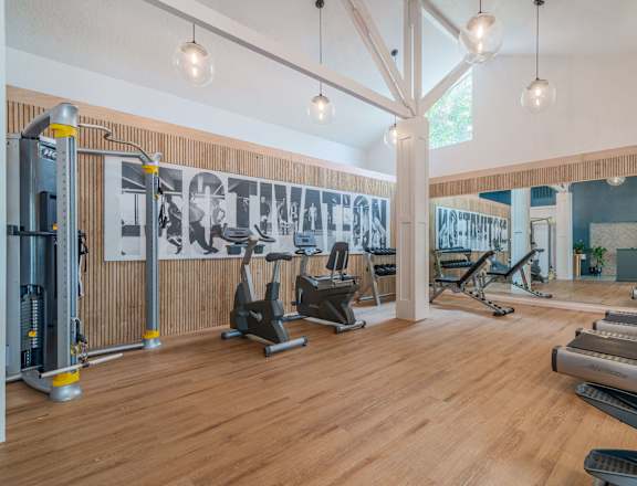 a gym with cardio machines and weights on a wooden floor at Napa Green Apartments LLC, Napa, CA 94559