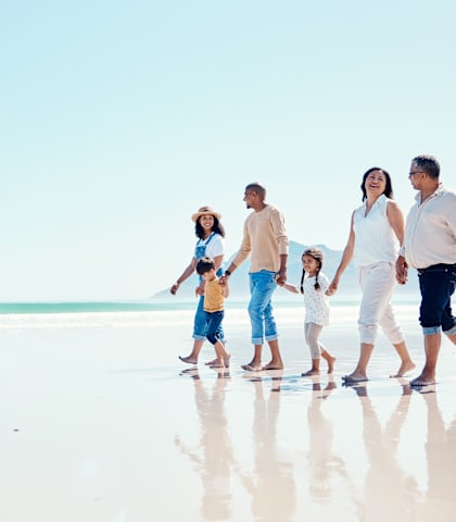 a family walking on the beach on a sunny day