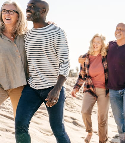 A group of people are walking on the beach.