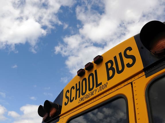 A school bus with the words "school bus" and "emergency door" written on it.