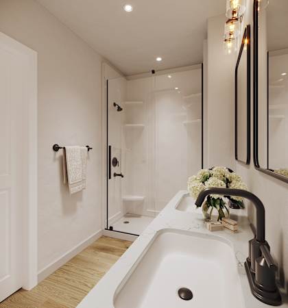 A white sink in a modern bathroom with a glass shower door.