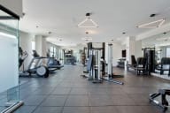 a gym with cardio equipment and weights on a tiled floor
