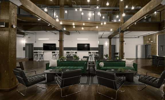 A modern office space with a green couch and black chairs.