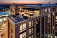 an aerial view of a building with a rooftop terrace at dusk