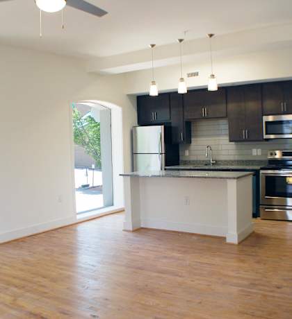 A kitchen with a refrigerator, microwave, and oven.