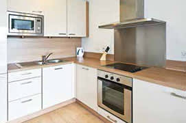 a kitchen with white cabinets and a stove and a microwave