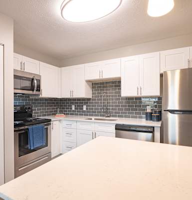 a kitchen with white cabinets and stainless steel appliances