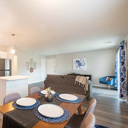 A modern kitchen with a dining table set for four.