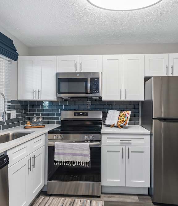 a kitchen with stainless steel appliances and white cabinets