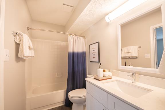 A white bathroom with a toilet, sink, and bathtub.