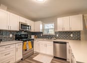 Thumbnail 4 of 8 - A kitchen with white cabinets and a black stove top.