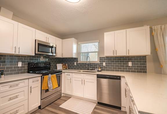 A kitchen with white cabinets and a black stove top.
